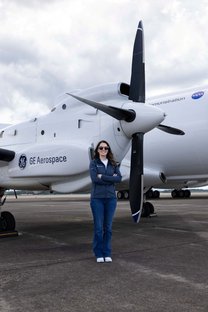Christine Andrews, who's been leading a team focused on hybrid electric propulsion, standing with a plane