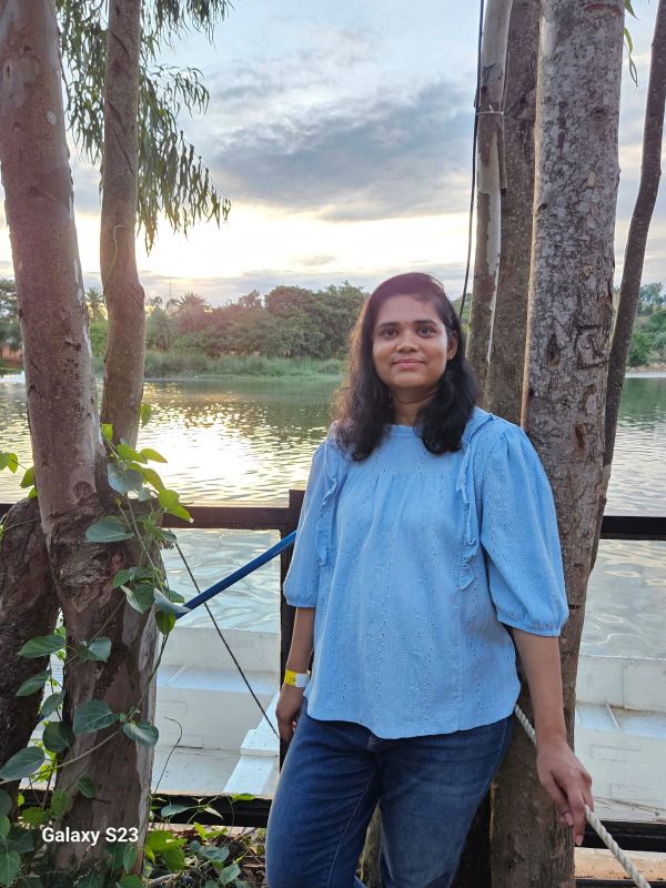 Woman stand in front of a lake near palm trees