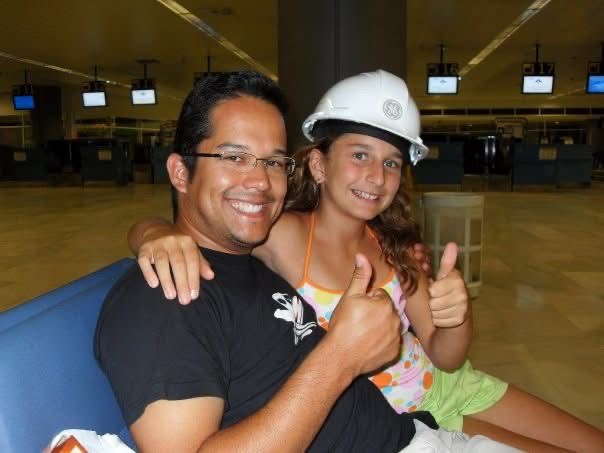Father and daughter giving thumbs ups with daughter wearing a GE hard hat