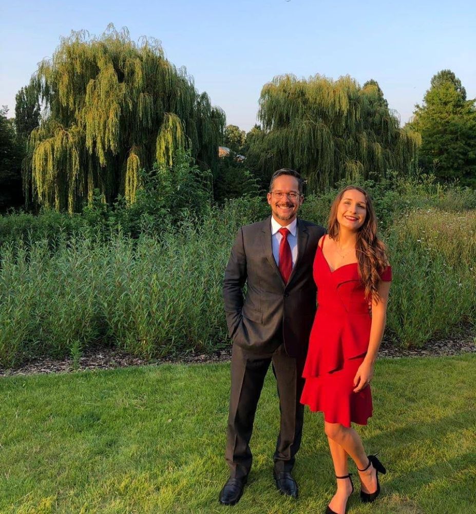 Man and daughter posing in nice outfits outdoors