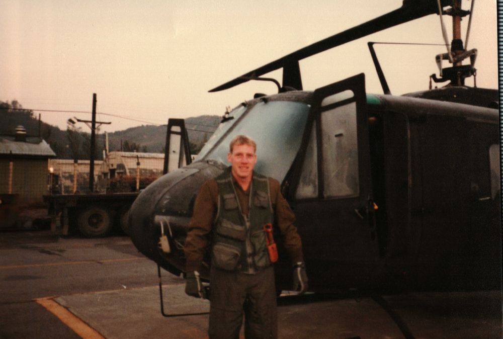 Kirby Luke stands with a large aircraft during his station assignment in South Korea, where he planned the annual meeting between various countries