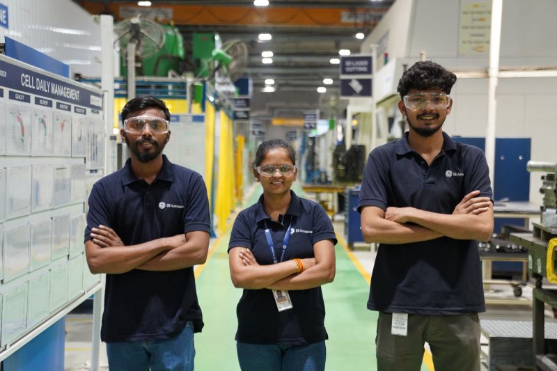 Three GE Aerospace engineers standing on the floor with their arms crossed