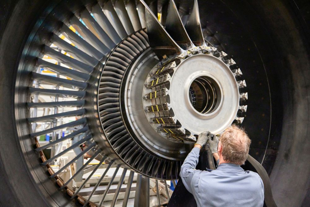 Man fitting a fan blade onto an engine