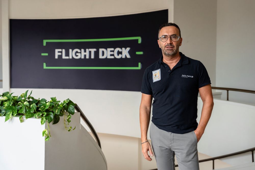 Roberto Bertaina stands in a black polo in front of a sign that reads "Flight Deck"