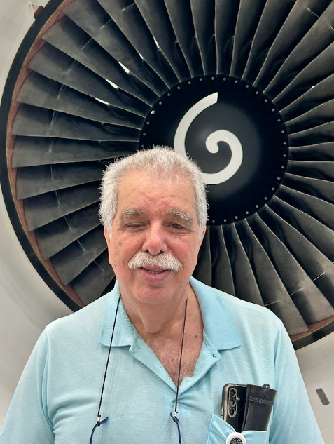 Man in a blue polo in front of an engine