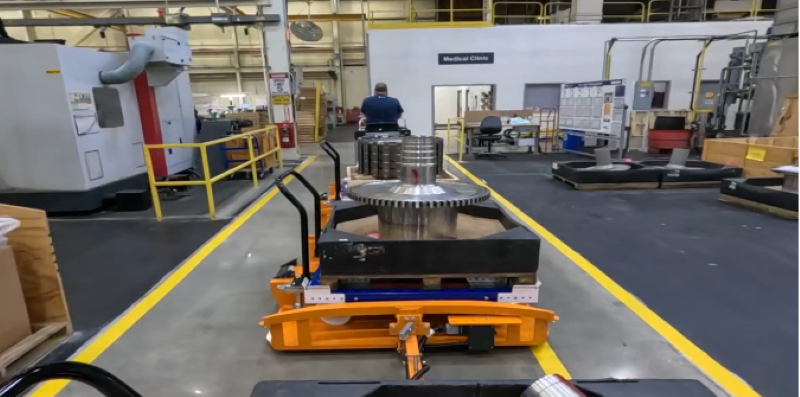 Man driving tugger through shop floor