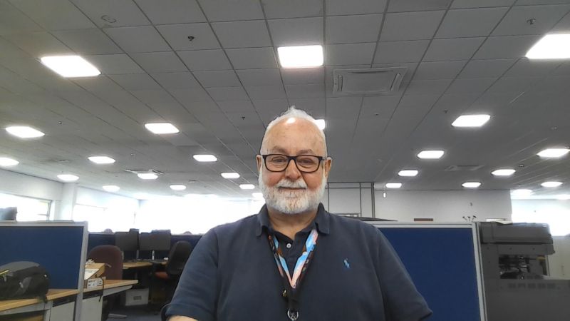 A selfie of Anthony in his office among cubicles.