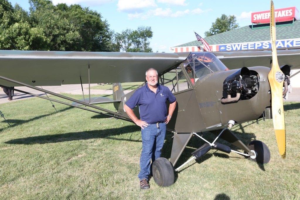 Beam standing in front of a Piper plane at Oshkosh.